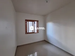 Vista de um corredor interno com paredes brancas e piso claro.