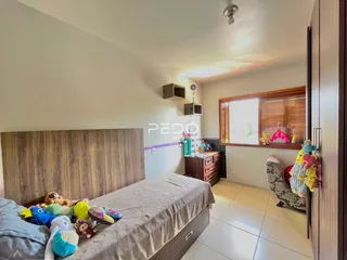 Quarto com cama e cabeceira de madeira em um imóvel no Brasil.