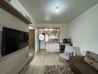 Foto da sala de estar com televisão e sofá.