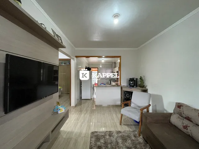 Foto da sala de estar com televisão e sofá.