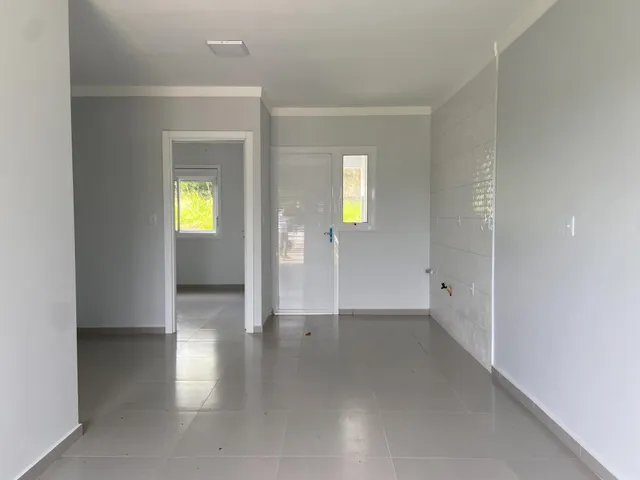 Hall de entrada com piso de cerâmica e paredes brancas.