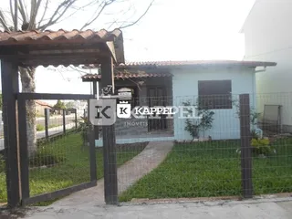 Fachada de uma casa em Lajeado, Brasil, com cerca e jardim na frente.