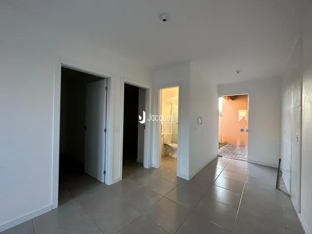 Hall de entrada com piso de cerâmica e portas de acesso a outros cômodos.