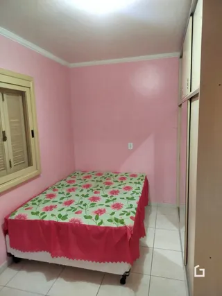 Foto de um quarto com paredes rosa e uma cama em um imóvel no Brasil.