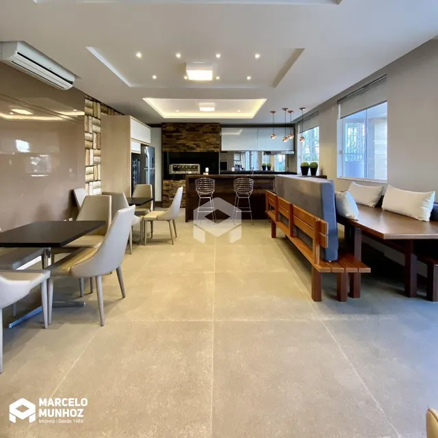 Interior de uma sala de estar com área de jantar e cozinha em uma residência.