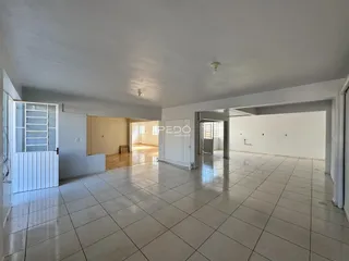 Interior de uma sala ampla com piso de cerâmica clara.