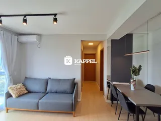 Sala de estar com sofá cinza e decoração moderna em um apartamento.