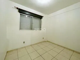 Ambiente interno com piso de cerâmica claro e paredes brancas.