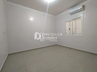 Ambiente interno de uma sala com piso de cerâmica e janela.