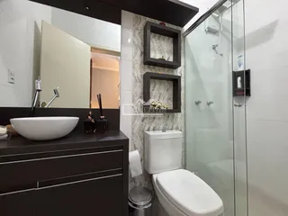 Foto de um banheiro moderno com bancada e box de vidro transparente.