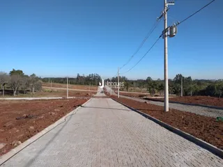 Uma estrada de terra se estende sob um céu azul.