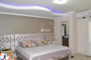 Quarto com cama e cabeceira decorada.