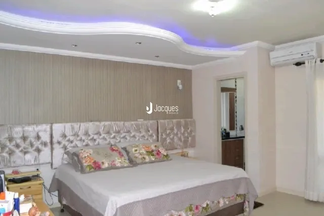 Quarto com cama e cabeceira decorada.
