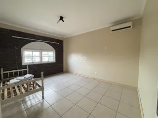 Quarto com cama de madeira e piso de cerâmica na sala.