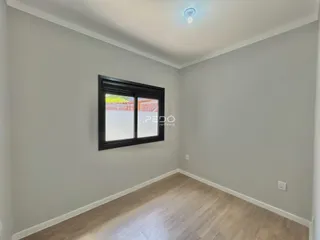 Ambiente interno de uma sala com paredes cinzas e piso de madeira clara.