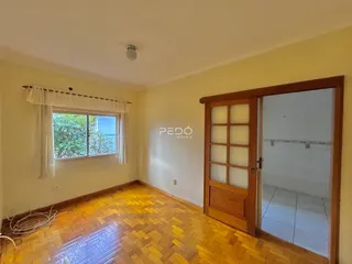 Sala com piso de madeira e porta de madeira em um imóvel no Brasil.
