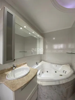 Foto de um banheiro com banheira branca e revestimento de mármore.