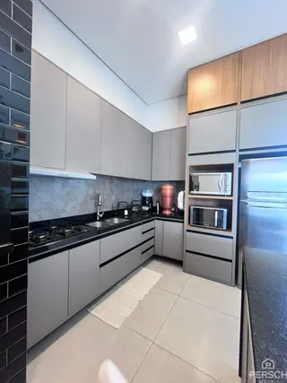 Foto de uma cozinha moderna com armários cinza e bancadas escuras.