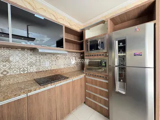 Cozinha moderna com armários de madeira e bancadas de granito.