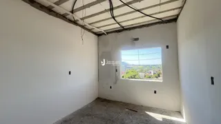 Interior de um cômodo com paredes brancas e teto exposto.