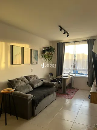 Sala de estar com sofá e janela em um imóvel no Brasil.