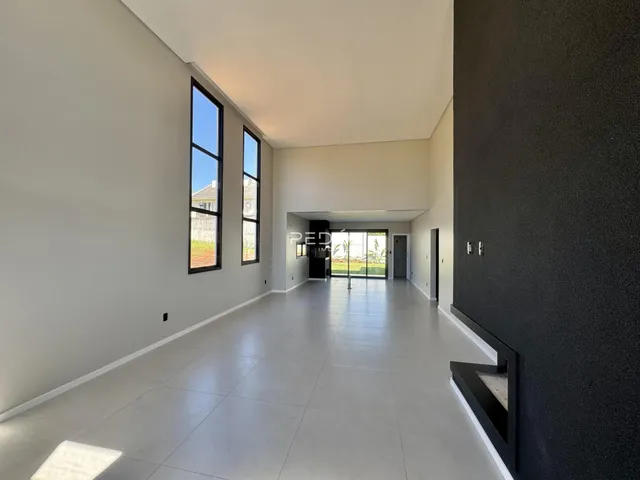 Interior de um corredor longo com paredes brancas e piso claro.