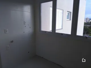 Parede interna branca com janela em uma residência.