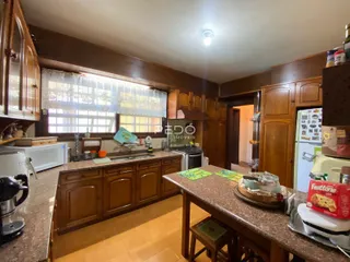 Foto de uma cozinha com armários de madeira e piso cerâmico.