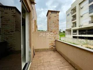 Vista externa de um pátio com piso de tijolos entre duas construções.