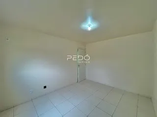 Foto de um ambiente interno com piso de cerâmica e paredes brancas.