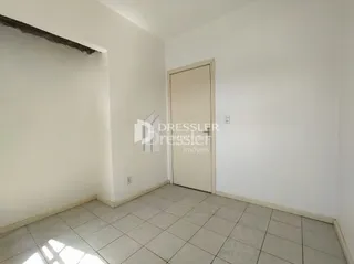 Interior de um ambiente com piso de cerâmica e paredes brancas.