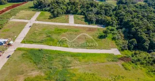 Vista aérea de um terreno aberto com vegetação e estradas.