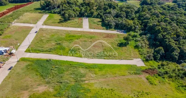 Vista aérea de um terreno aberto com vegetação e estradas.