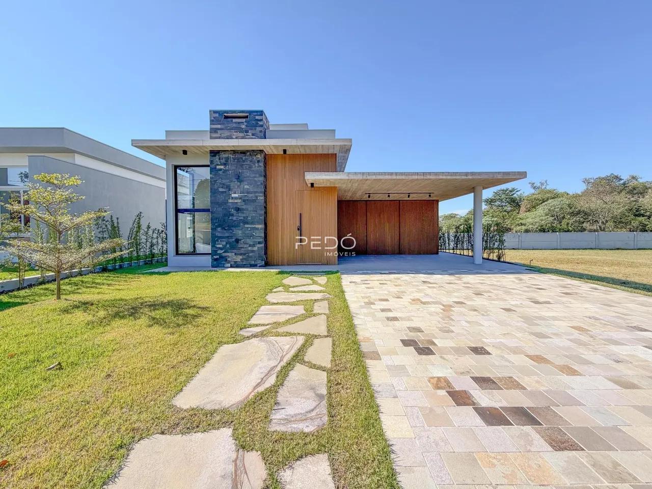 Fachada de uma casa moderna com área externa pavimentada em Lajeado, Brasil.