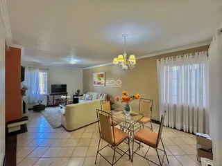 Sala de estar com sofá e mesa de jantar de vime em um imóvel no Brasil.