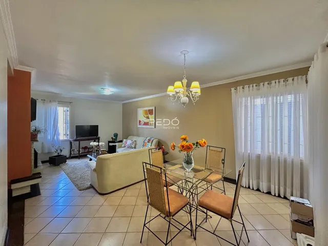 Sala de estar com sofá e mesa de jantar de vime em um imóvel no Brasil.