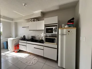 Cozinha moderna com armários brancos e eletrodomésticos.