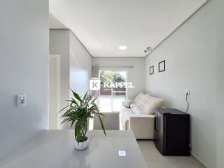 Sala de estar moderna com sofá e planta decorativa.
