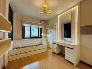Quarto com cama de madeira e piso de madeira clara.