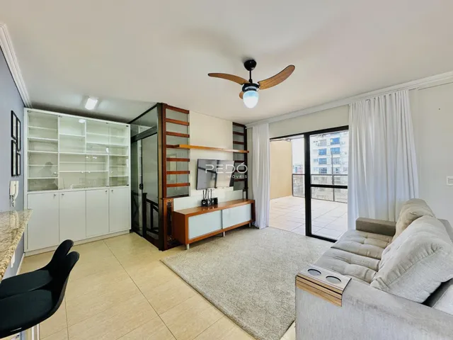 Sala de estar com sofá e painel de TV em um apartamento no Brasil.