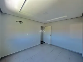 Interior de uma sala com paredes brancas e piso de cerâmica.