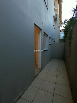 Vista de um corredor externo entre duas edificações.