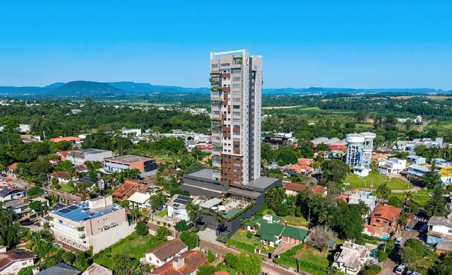 Vista aérea de um bairro residencial com casas e áreas verdes em Lajeado, Brasil.