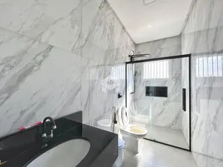 Banheiro com revestimento de mármore nas paredes e piso.