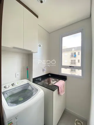 Foto de um ambiente interno com pia e máquina de lavar roupa.