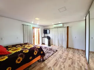 Quarto com cama e piso de madeira.