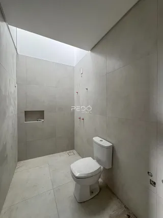 Foto de um banheiro com revestimento de azulejo cinza nas paredes.
