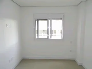 Foto de uma sala de estar branca com janela.