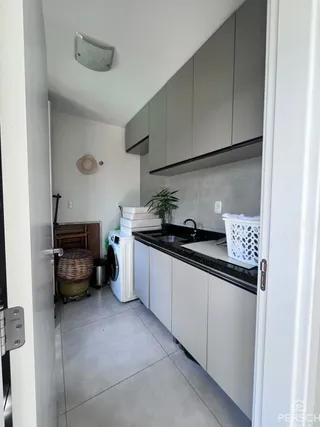 Cozinha moderna com armários superiores cinzas e bancada escura.