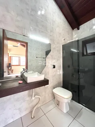 Foto de um banheiro com azulejos brancos e box de vidro.